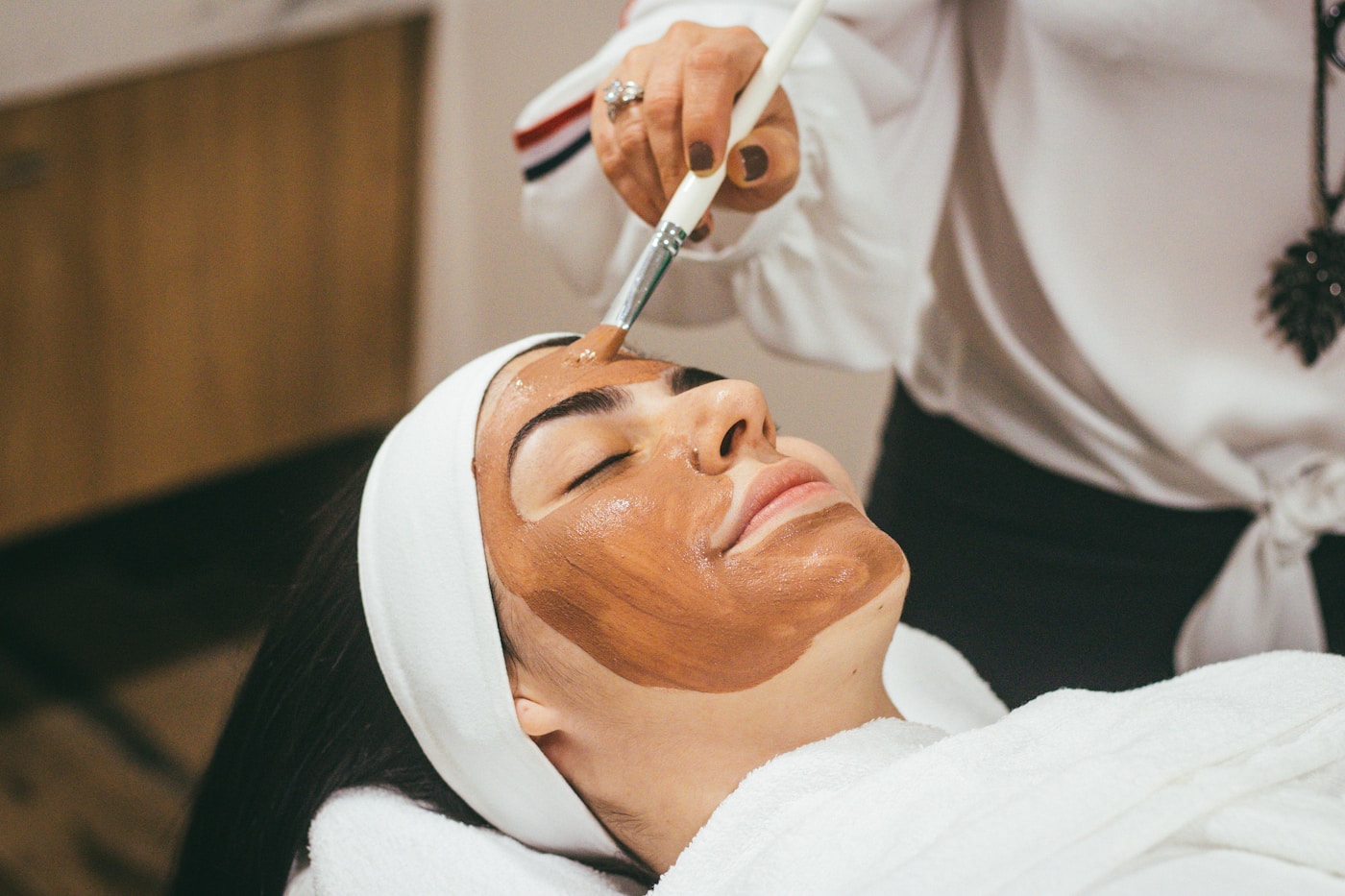 Aplicação de cuidado facial em imagem ilustrativa; não representa tratamento com ácido azelaico.