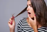 Pessoa observando uma ponta do cabelo em imagem ilustrativa sobre avaliação do estado dos fios