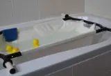 Imagem ilustrativa de uma estrutura de banho infantil com suporte e água