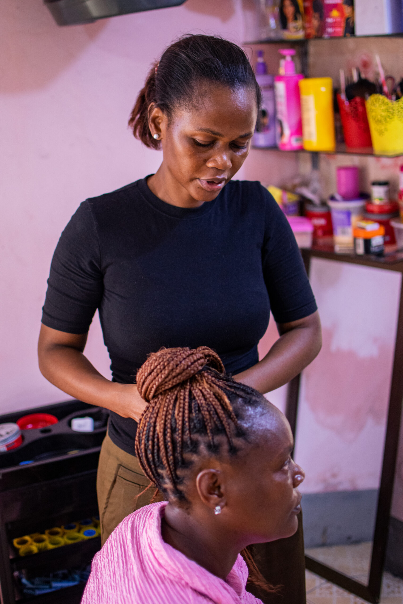 Pessoa com corte de cabelo curto em um salão, com produtos e ferramentas ao fundo