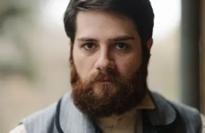 Homem com barba cheia e bem aparada em retrato ilustrativo