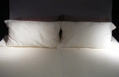 Duas fronhas sobre uma cama, em imagem ilustrativa que não identifica o tecido