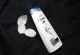 Frasco de shampoo Dove fotografado sobre tecido escuro