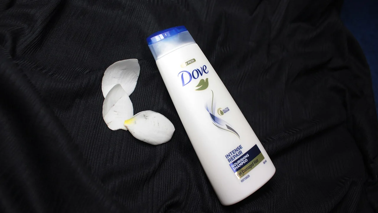 Frasco de shampoo Dove fotografado sobre tecido escuro
