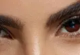 Close de olhos e sobrancelhas bem definidas, imagem ilustrativa para guia de produtos de sobrancelhas.