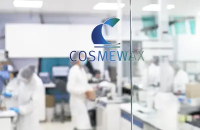 Laboratório de fabricação de cosméticos com profissionais usando equipamentos de proteção.