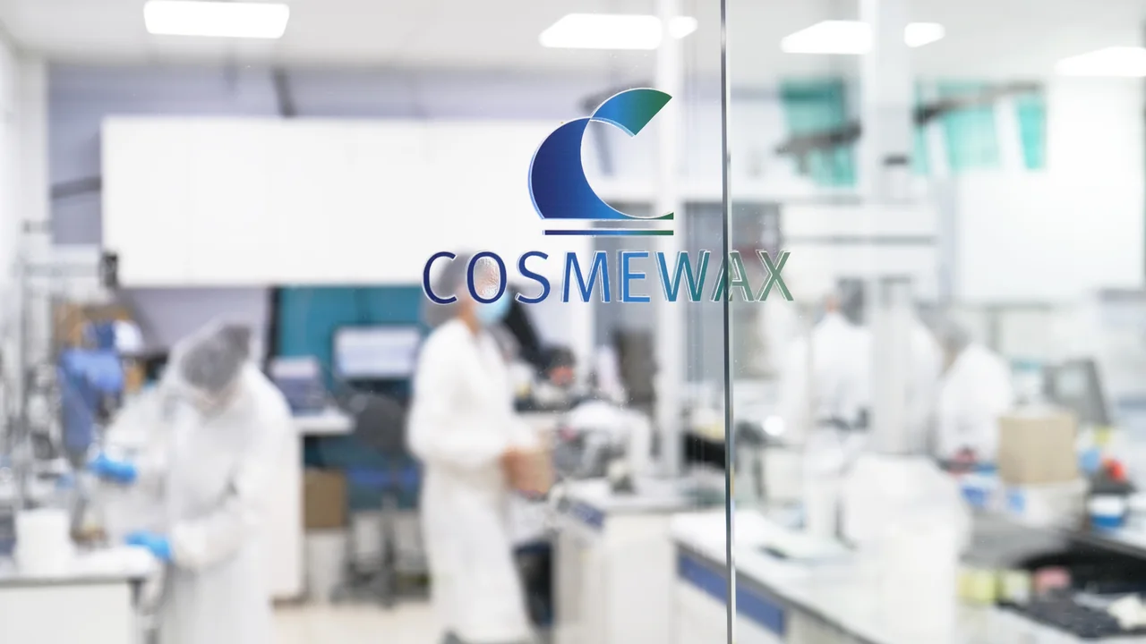 Laboratório de fabricação de cosméticos com profissionais usando equipamentos de proteção.