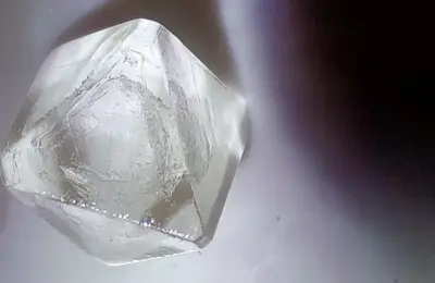 Cristal transparente de alúmen fotografado em detalhe; imagem ilustrativa do mineral usado em alguns desodorantes cristal.