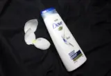 Frasco de shampoo Dove Nutrição Intensa fotografado sobre tecido escuro