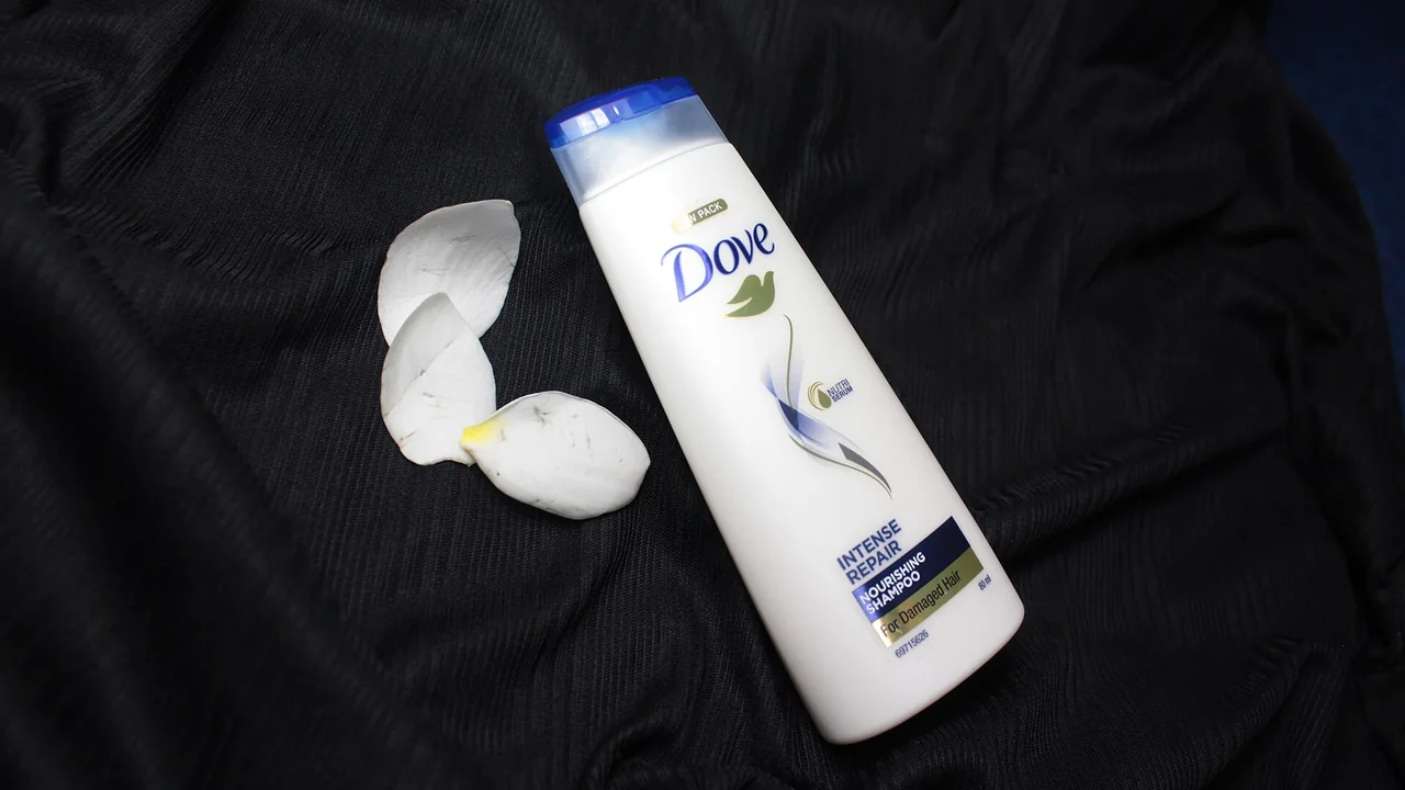 Frasco de shampoo Dove Nutrição Intensa fotografado sobre tecido escuro