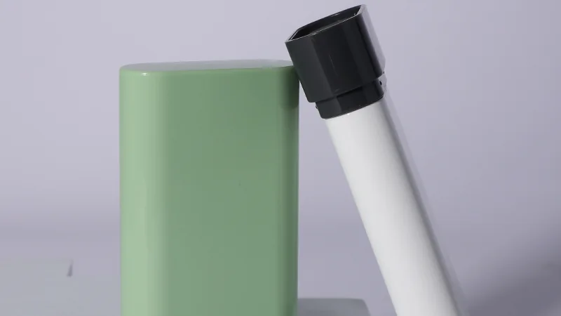 Embalagem em bastão para perfume sólido com aplicador branco e tampa preta