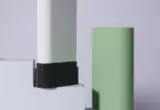 Embalagem oval em bastão para perfume sólido, apresentada fechada em verde e aberta em branco
