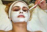 Aplicação de máscara facial branca com pincel sobre o rosto