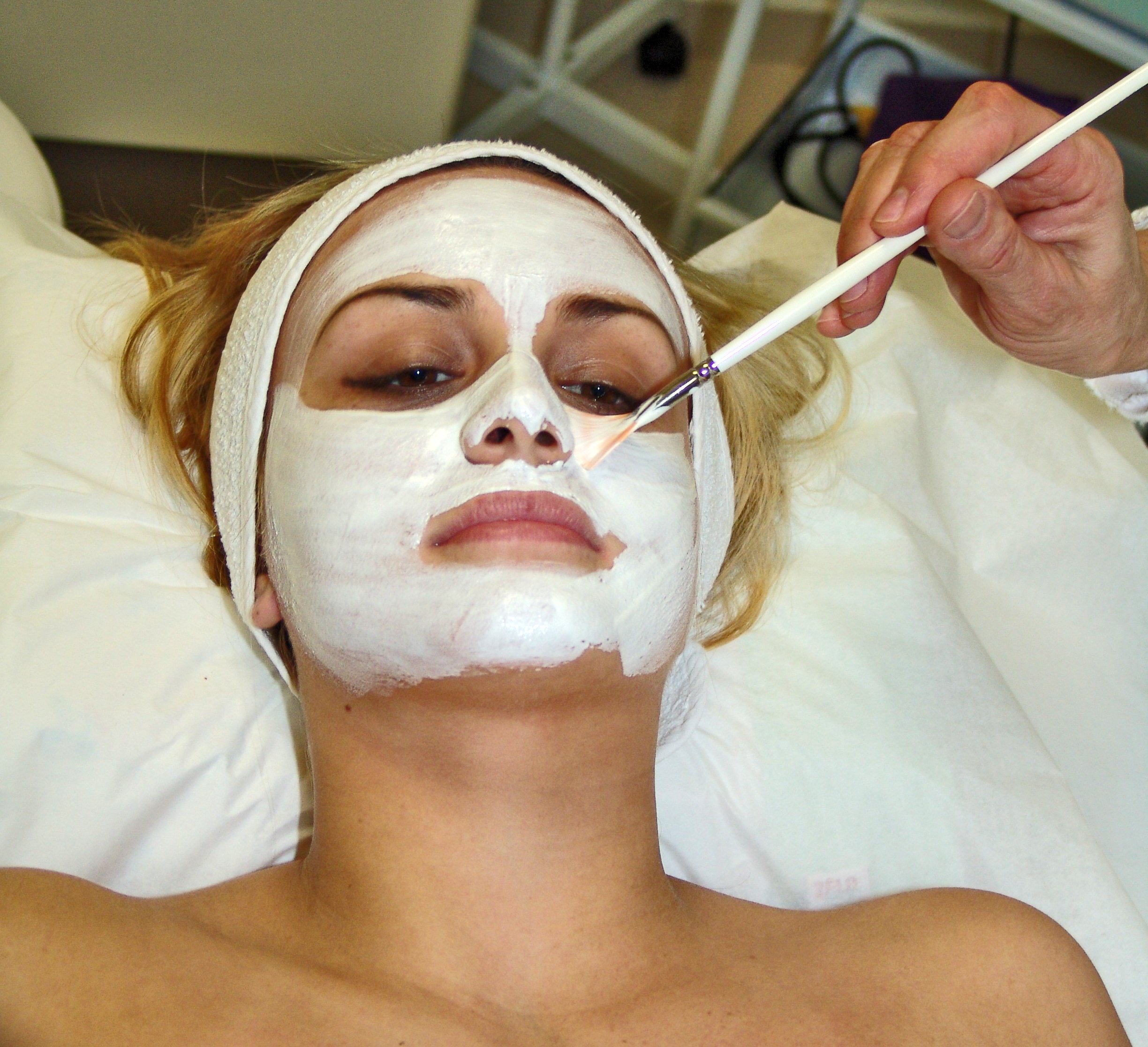 Aplicação de máscara facial branca com pincel sobre o rosto