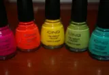 Frascos coloridos de esmalte reunidos sobre uma superfície de madeira, em imagem ilustrativa