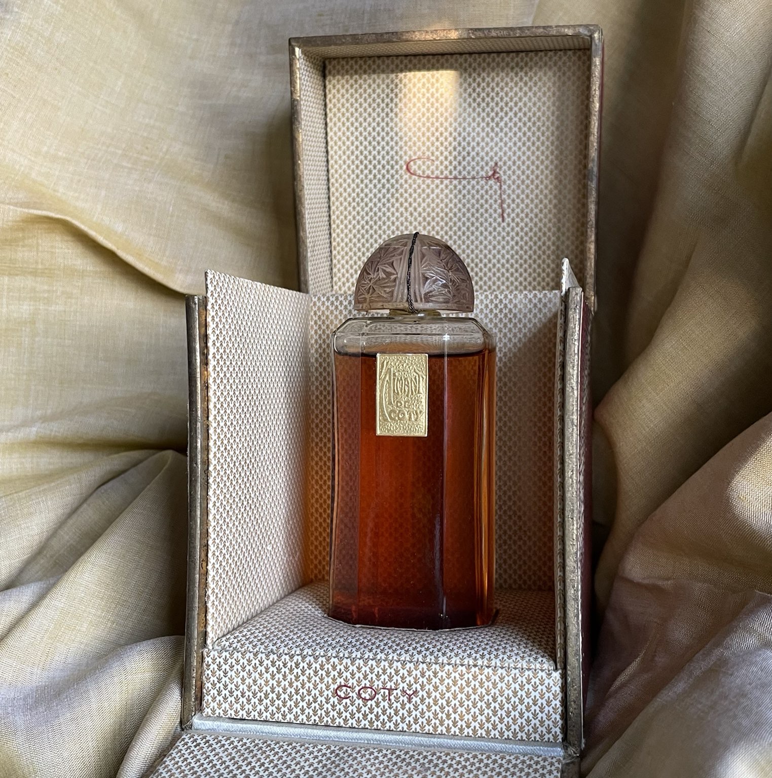 Frasco histórico de perfume em embalagem original, imagem ilustrativa sobre concentração e perfumaria