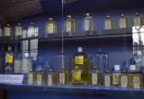 Frascos de perfume em vitrine, com rótulos visíveis para ilustrar a conferência de informações em embalagens cosméticas.