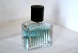 Frasco de perfume em vidro com líquido azul-claro, usado como ilustração de fragrância leve