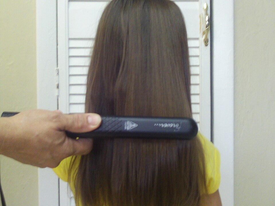 Chapinha alisando uma mecha de cabelo