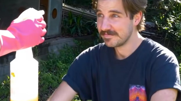 Pessoa diante de um borrifador em cena ilustrativa de uso de spray
