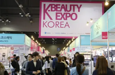 Corredor de uma feira K-Beauty Expo Korea com estandes de marcas de beleza e visitantes