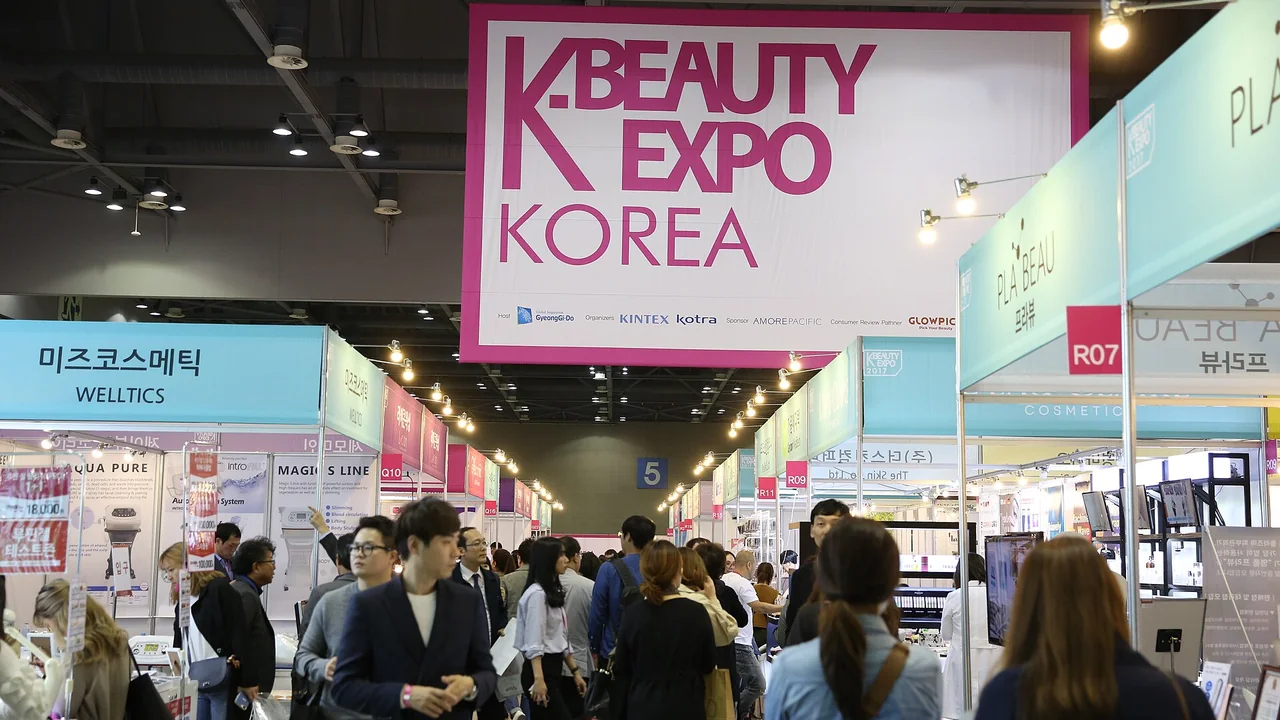 Corredor de uma feira K-Beauty Expo Korea com estandes de marcas de beleza e visitantes