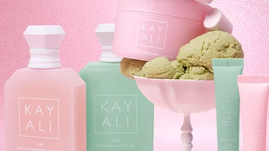 KAYALI Yum Lip & Body com frascos de perfume, creme corporal e balm labial em composição rosa e verde.