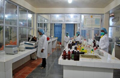 Profissionais trabalhando em laboratório de controle de qualidade com instrumentos e amostras