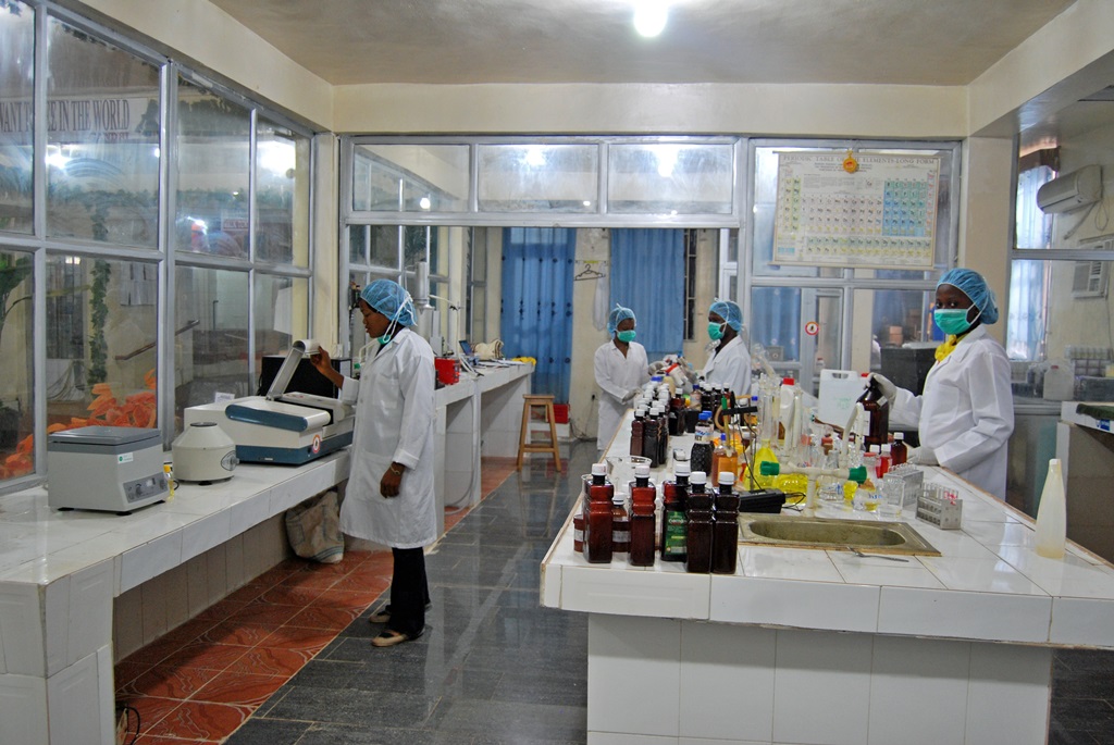 Profissionais trabalhando em laboratório de controle de qualidade com instrumentos e amostras