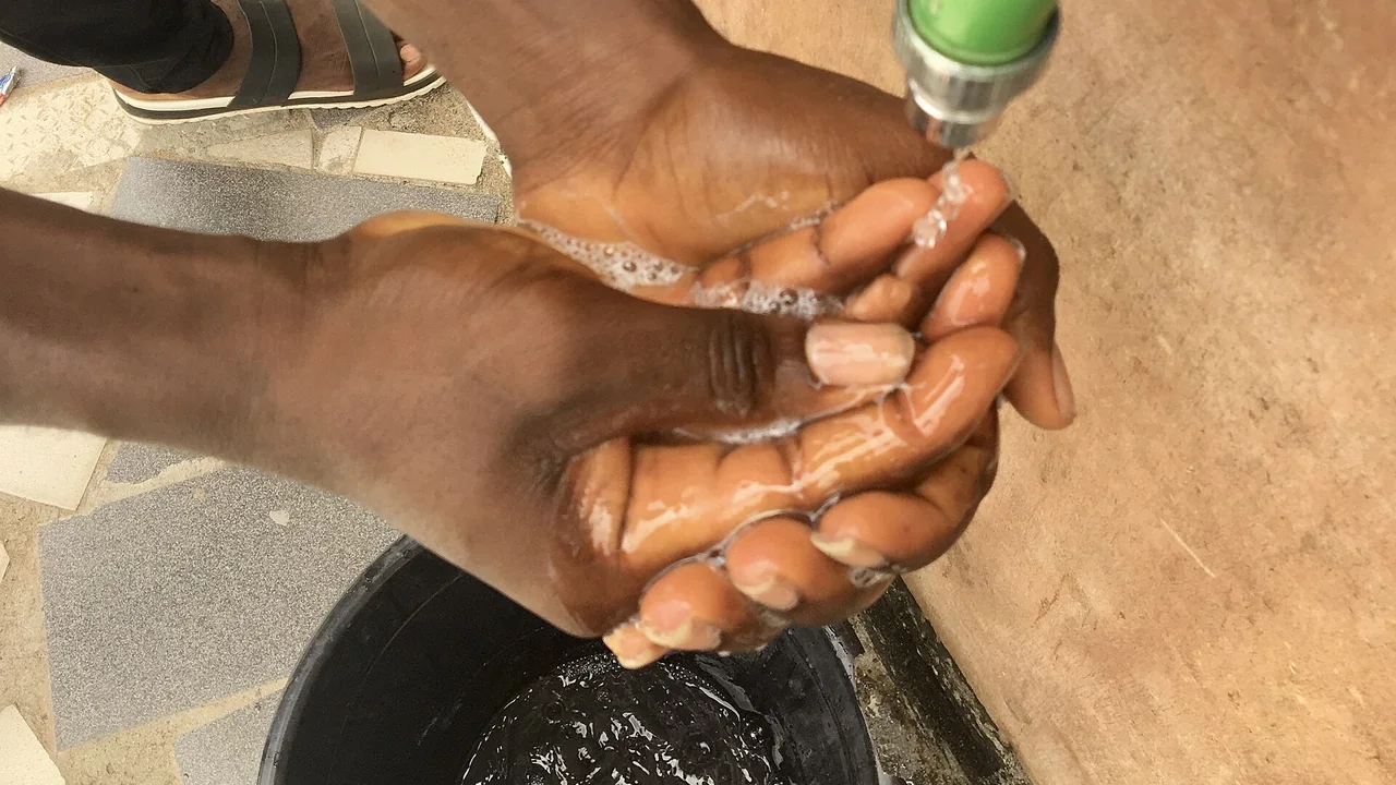 Mãos sendo lavadas com água e sabonete líquido