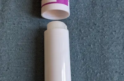 produto de cuidado labial em bastão sobre tecido azul