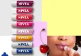 Imagem editorial com vários hidratantes labiais NIVEA e aplicação de produto nos lábios.