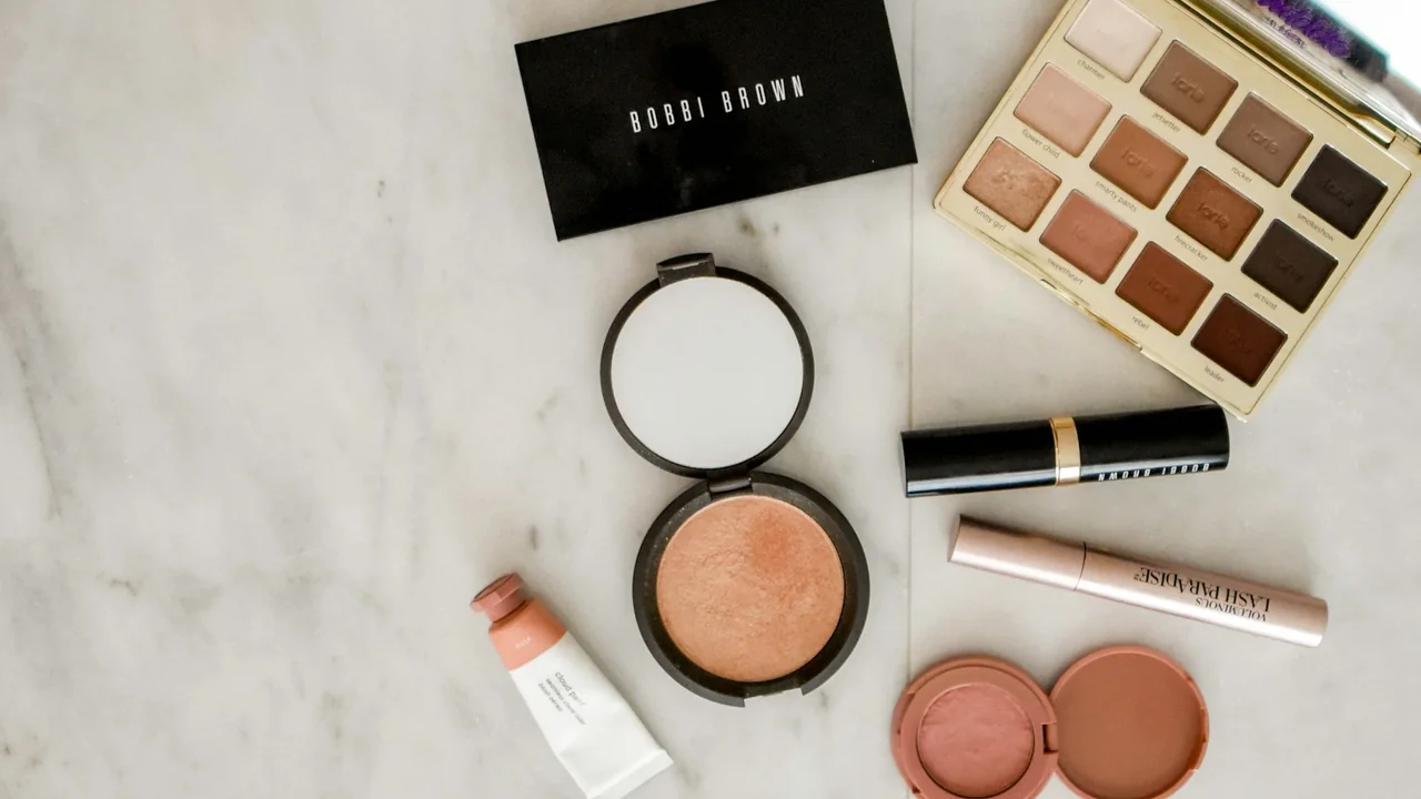 Produtos e paleta de maquiagem sobre uma superfície, imagem ilustrativa para explicar a aplicação de blush.