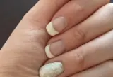 Unhas em manicure francesa com detalhe de brilho; imagem ilustrativa de cuidados com as unhas.