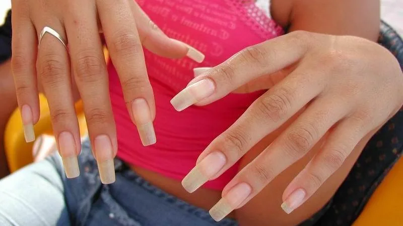 Mãos com unhas naturais em uma cena ilustrativa de cuidados e hidratação das cutículas