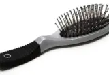 Escova de cabelo com almofada e pinos metálicos sobre fundo branco