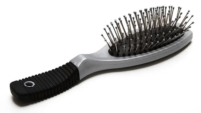 Escova de cabelo com almofada e pinos metálicos sobre fundo branco