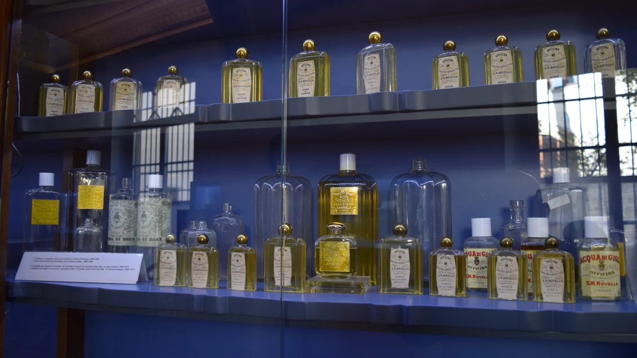 Mostruário com frascos de perfumes e cosméticos de formatos variados, destacando rótulos e embalagens.