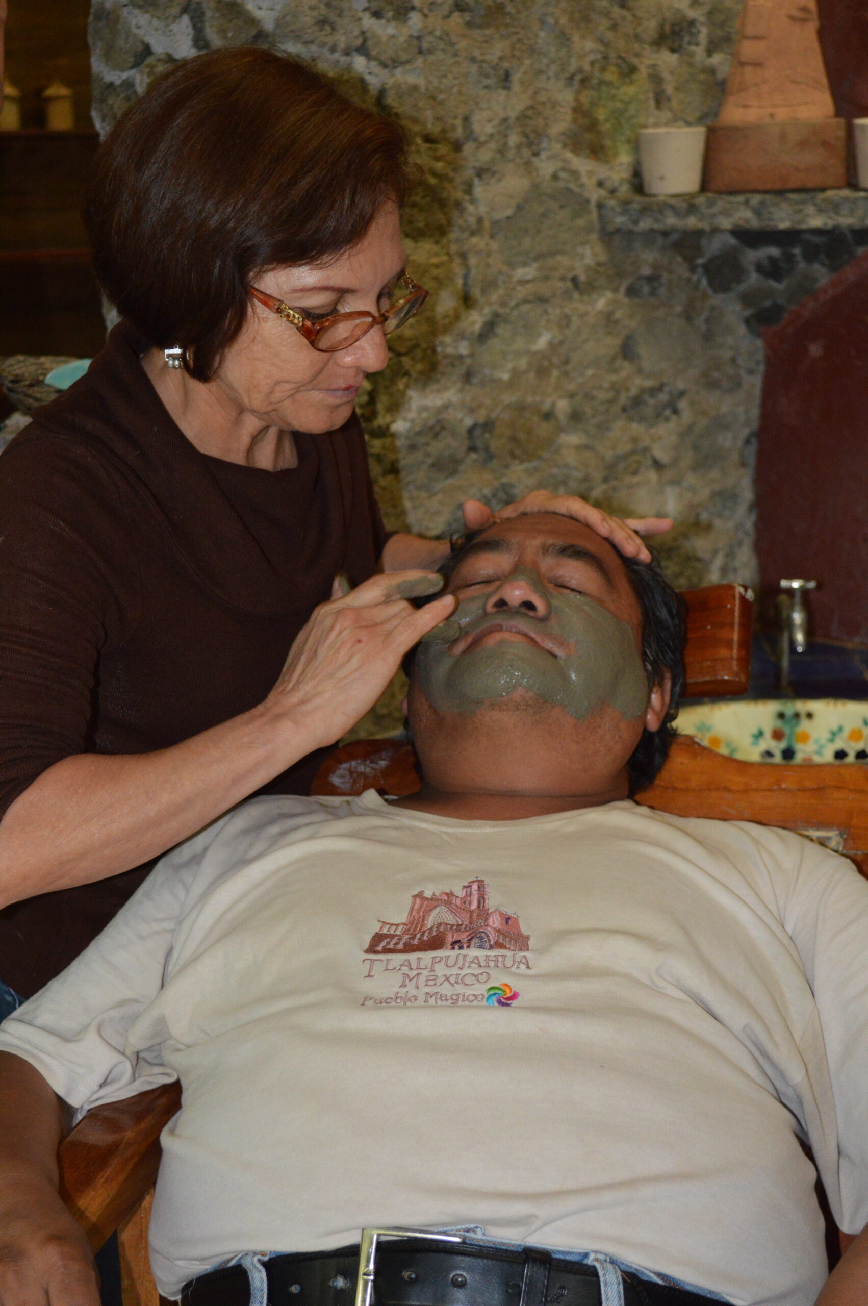 Pessoa com máscara facial branca sendo atendida durante aplicação