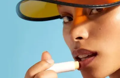 Imagem de pessoa aplicando produto labial em bastão, usada como exemplo visual de cuidado dos lábios.