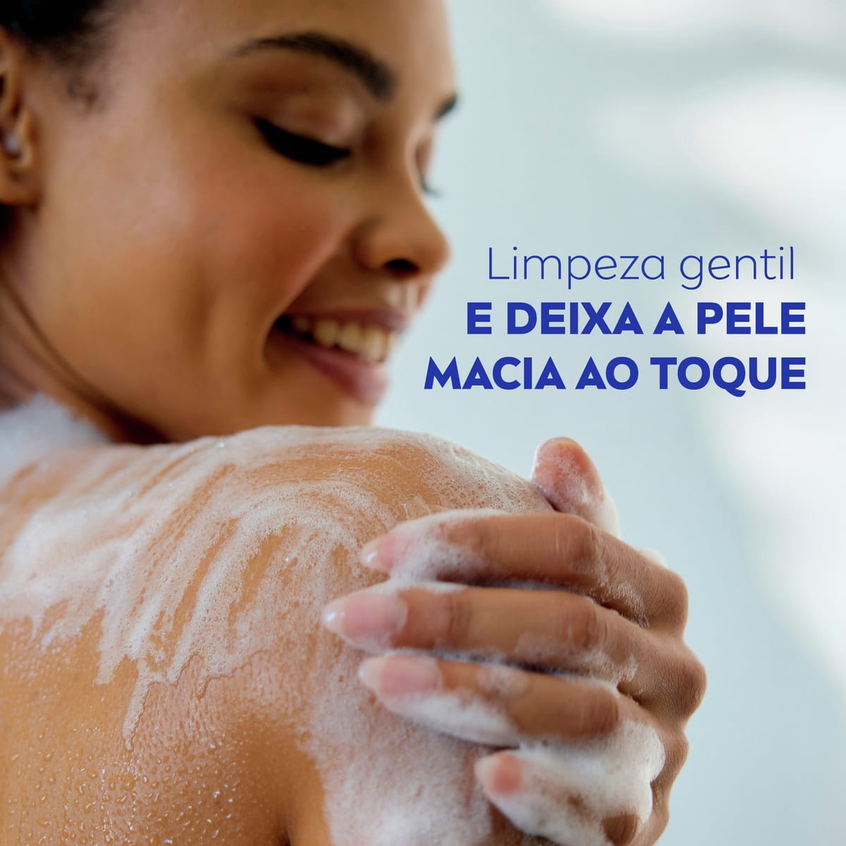 Pessoa ensaboando o ombro durante o banho com espuma do sabonete líquido NIVEA Creme Care