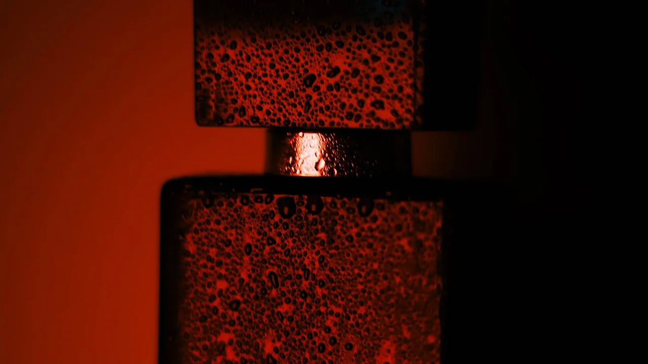 Close de frasco de perfume com gotas de água, imagem ilustrativa
