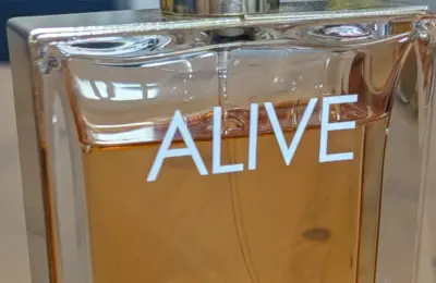 Frasco de perfume com líquido âmbar em close, imagem ilustrativa de perfumaria