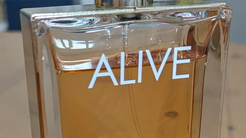 Frasco de perfume com líquido âmbar em close, imagem ilustrativa de perfumaria