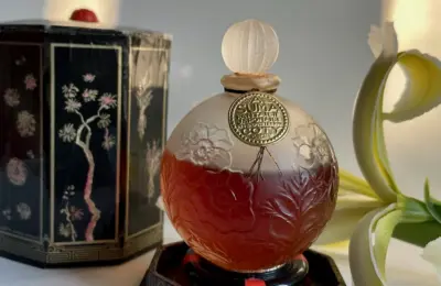 Frasco redondo do perfume A Suma, de Coty, em imagem ilustrativa sobre formatos de perfumaria