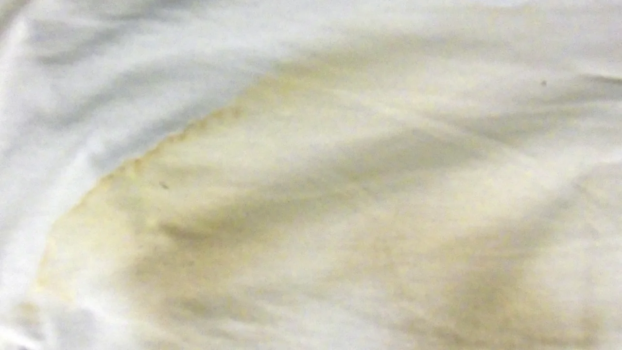 Mancha amarelada de transpiração em camiseta branca, imagem ilustrativa