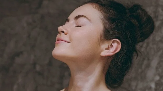 Rosto de mulher com maquiagem leve, em cena ilustrativa para uso de bruma facial
