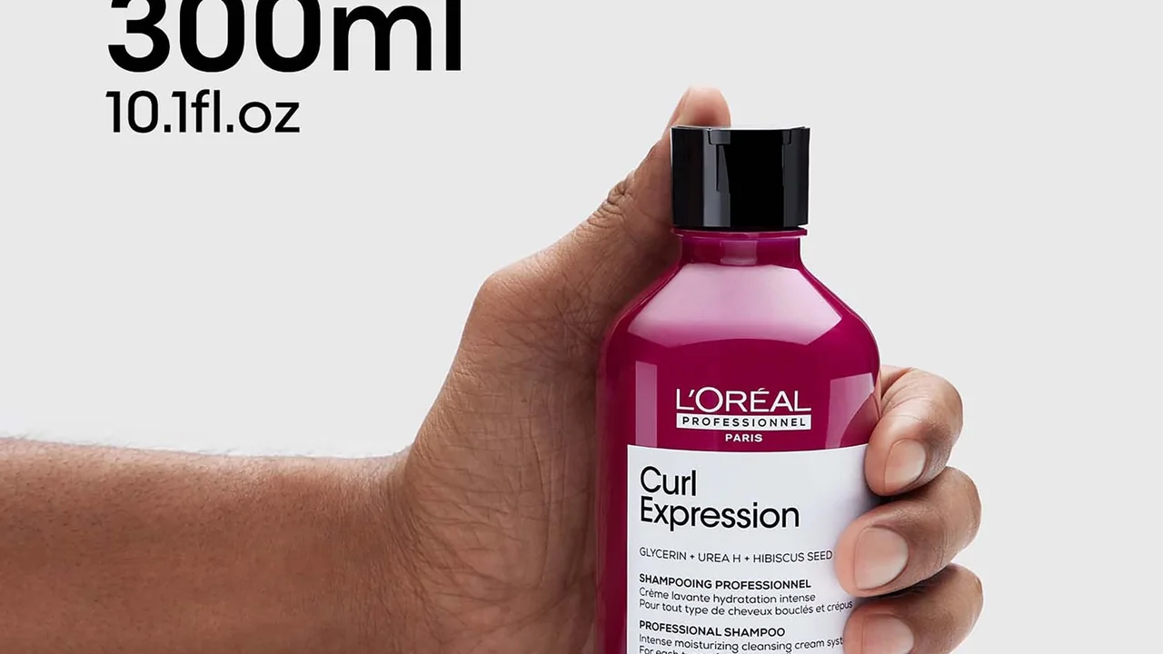 Mão segurando o frasco de shampoo antirresíduos L’Oréal Professionnel Curl Expression de 300 ml