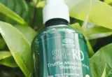 shampoo para cabelo com progressiva em embalagem entre folhas verdes