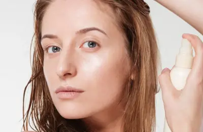 Spray fixador aplicado próximo ao cabelo, imagem ilustrativa baseada em material da L’Oréal Paris.